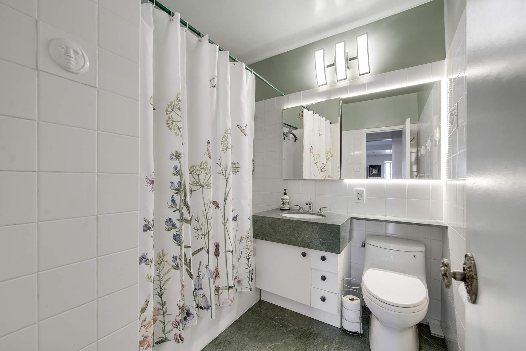 300 East 74th Street, Unit 14F Manhattan, NY 10021 - Photo 7 of 13 a bathroom with a toilet sink and mirror