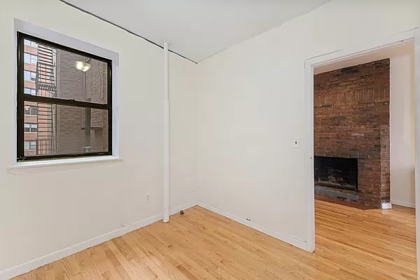 309 East 95th Street, Unit 17 Manhattan, NY 10128 - Photo 4 of 4 a view of empty room with wooden floor and fireplace