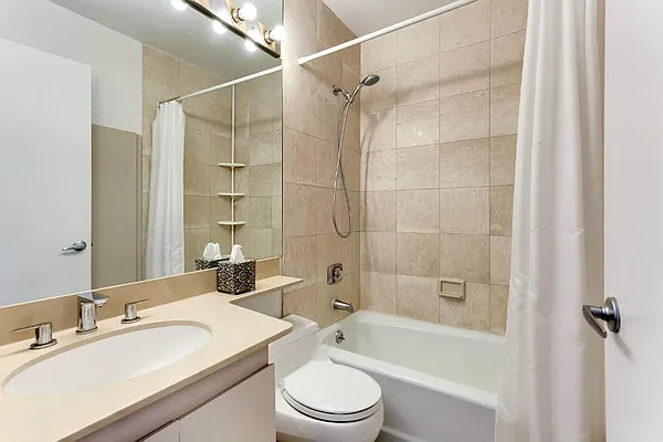330 East 75th Street, Unit 11D Manhattan, NY 10021 - Photo 4 of 7 a bathroom with a sink toilet vanity and shower