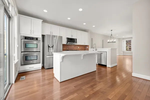 a kitchen with stainless steel appliances a refrigerator and a stove top oven