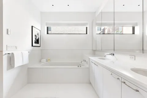 a bathroom with a tub a sink and mirror