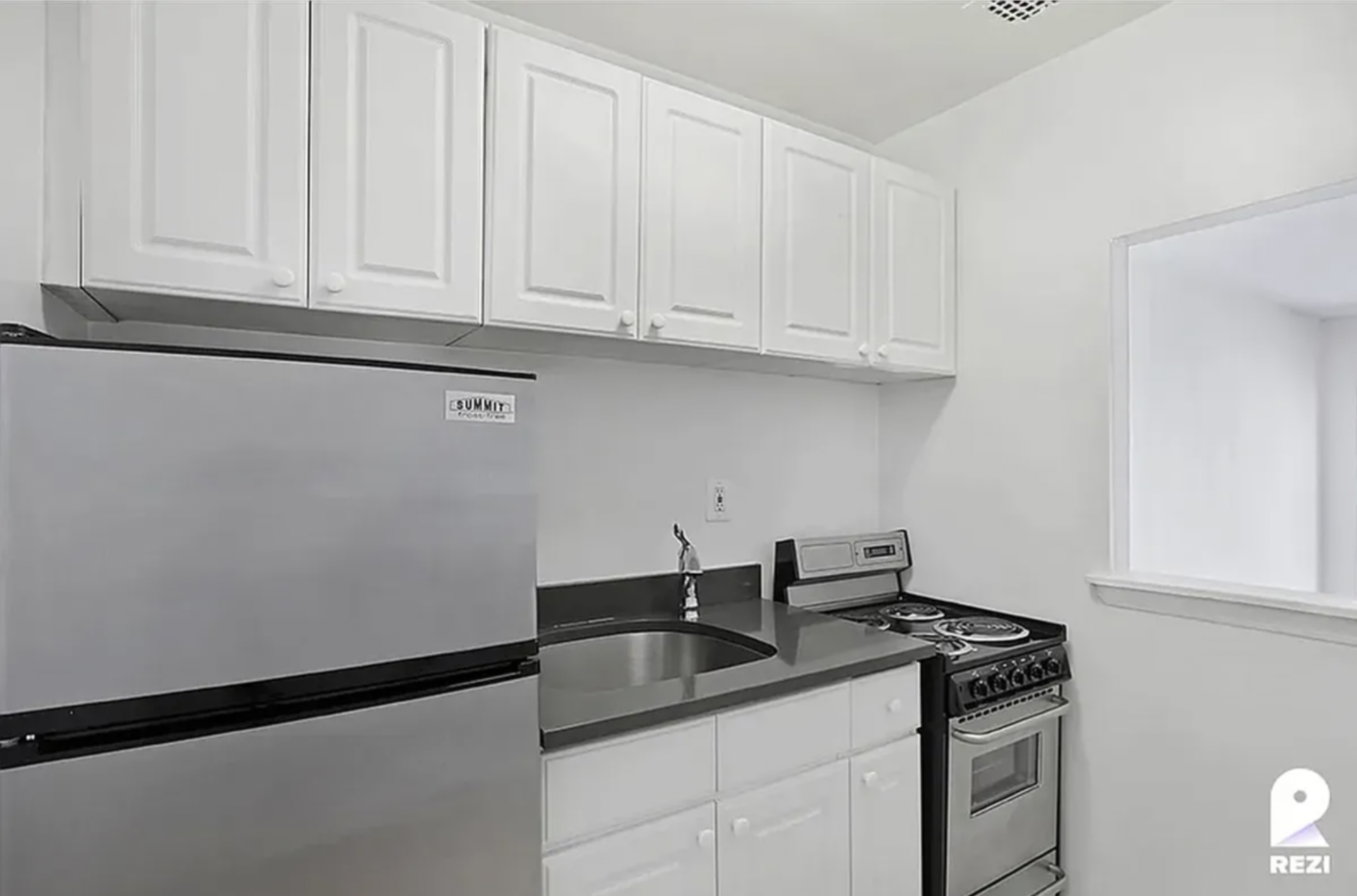 343 East 76th Street, Unit 2A Manhattan, NY 10021 - Photo 4 of 9 a kitchen with granite countertop white cabinets and a sink