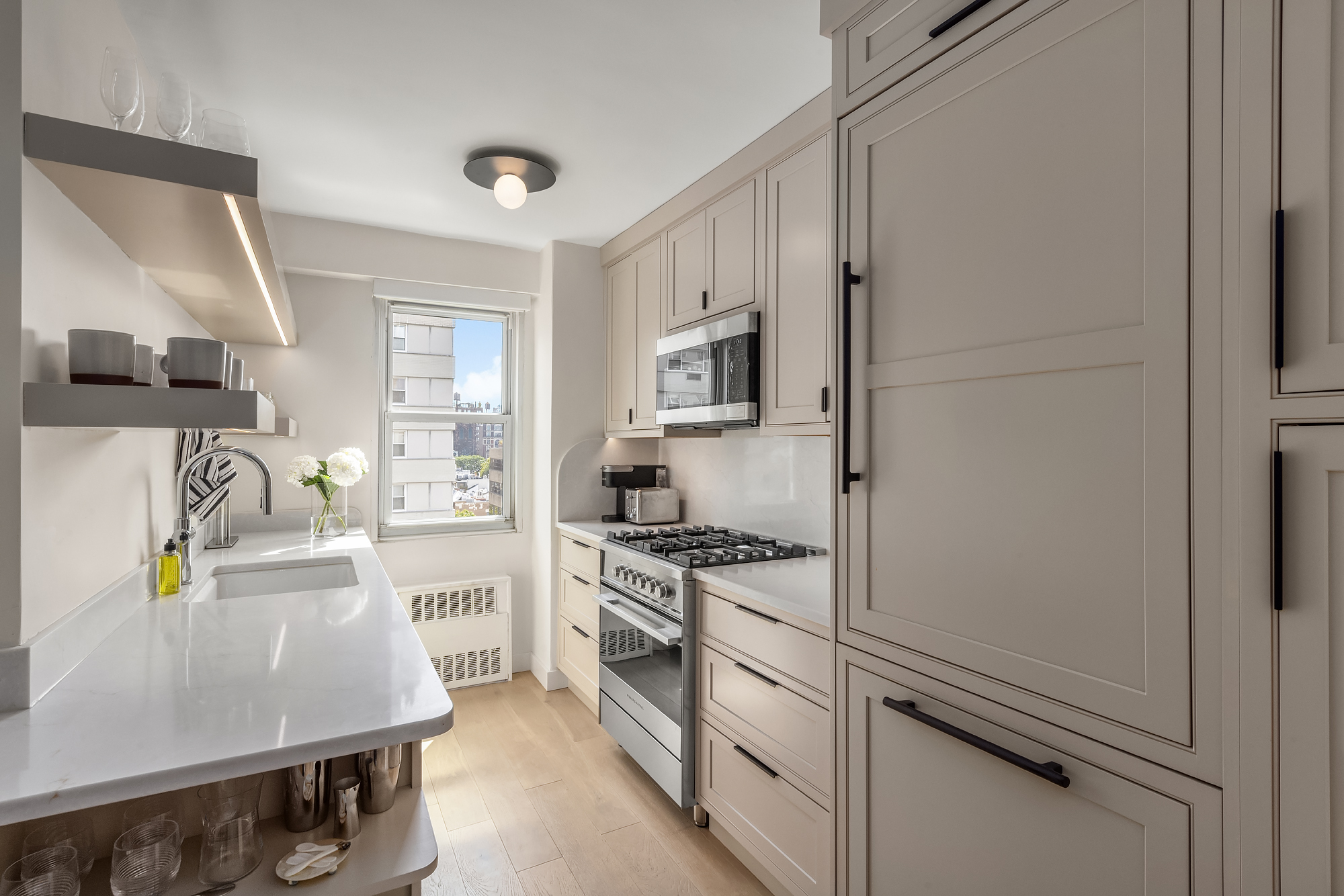 101 West 12th Street, Unit 12R Manhattan, NY 10011 - Photo 9 of 21 a kitchen with stainless steel appliances a stove a sink and a refrigerator