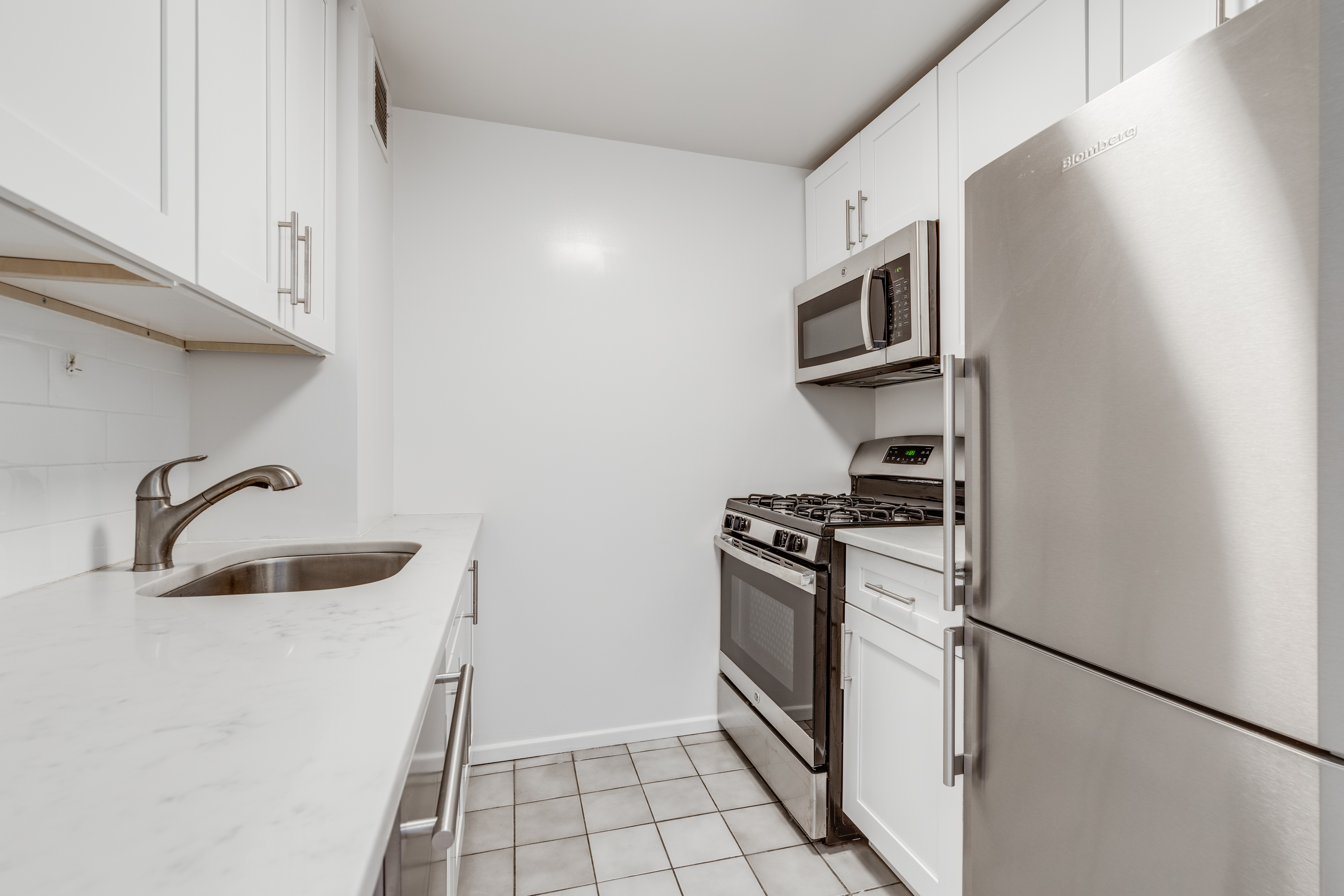 50 Lexington Avenue, Unit 12G Manhattan, NY 10010 - Photo 3 of 8 a kitchen with stainless steel appliances granite countertop a refrigerator and a sink