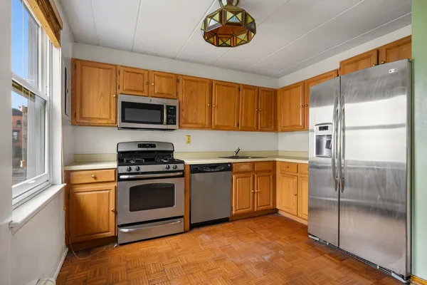 a kitchen with stainless steel appliances granite countertop a refrigerator a stove top oven a sink and dishwasher