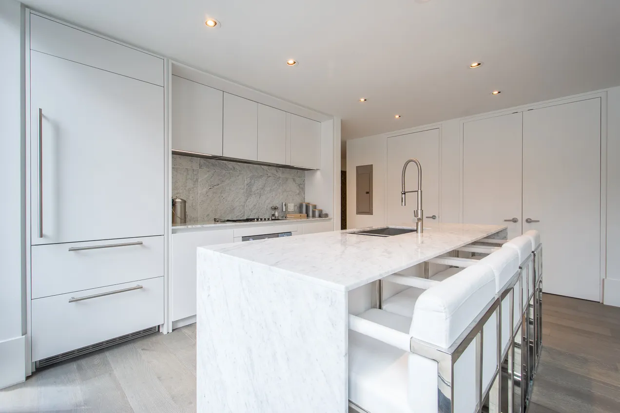 a kitchen with a sink a stove a refrigerator and white cabinets