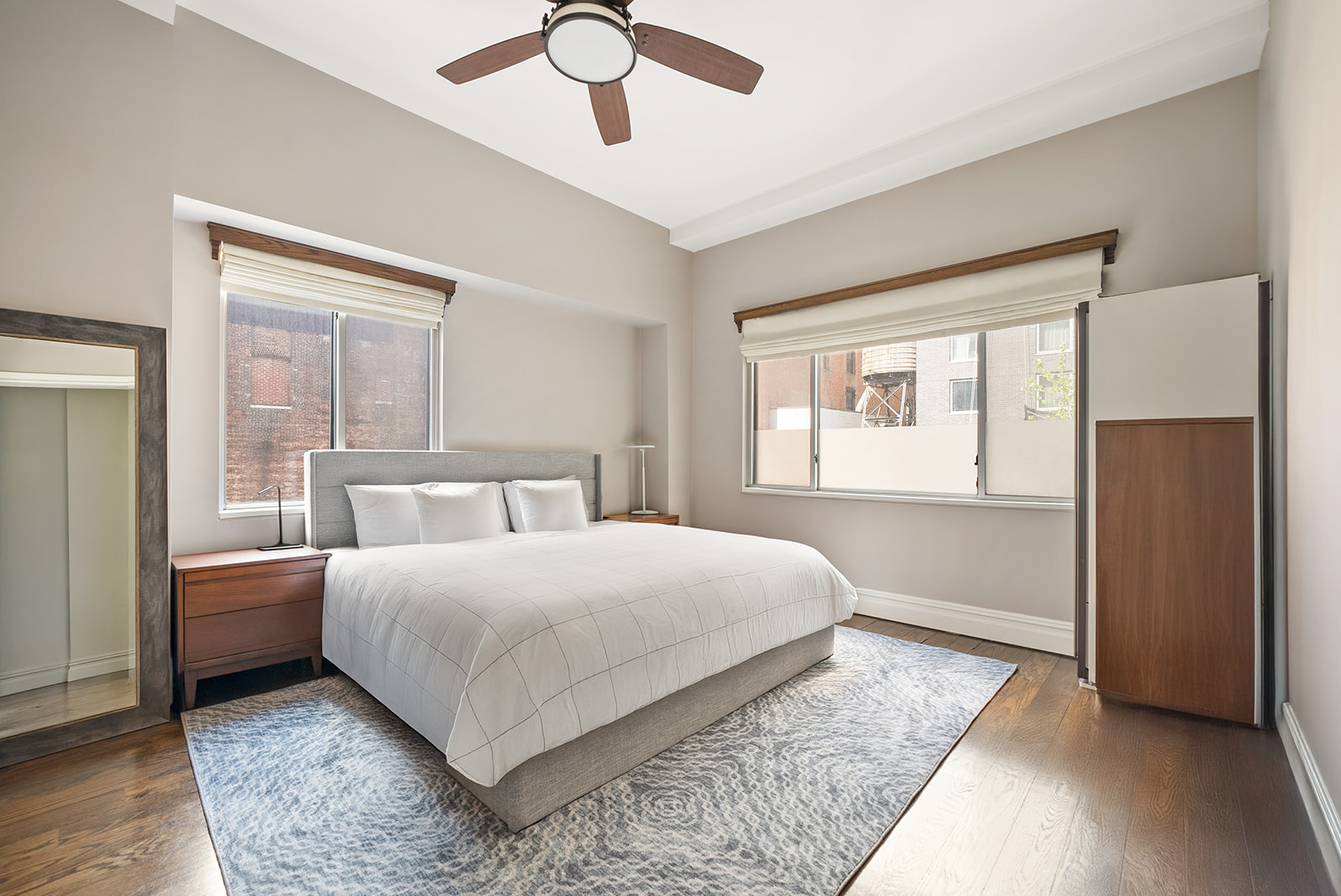 119 Fulton Street, Unit 8 Manhattan, NY 10038 - Photo 3 of 12 a bedroom with a large bed chandelier and a window