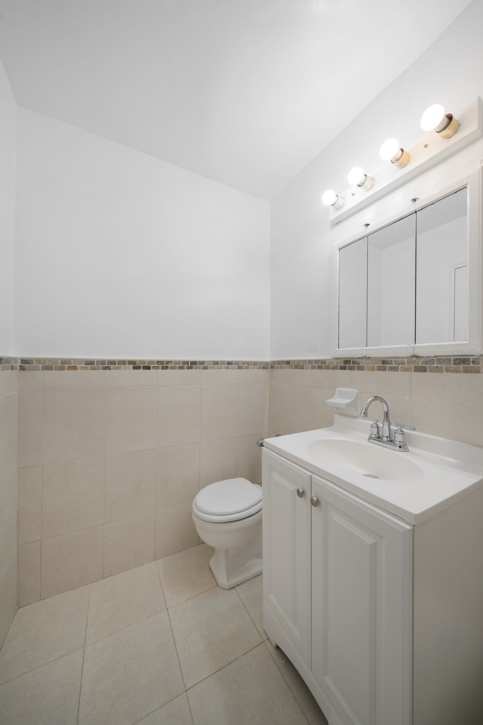 1270 East 51st Street, Unit 6M Brooklyn, NY 11234 - Photo 8 of 12 a bathroom with a sink a toilet and mirror