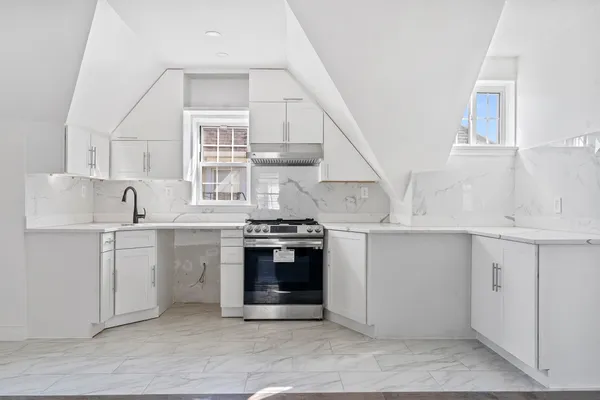 a kitchen with cabinets appliances and a window