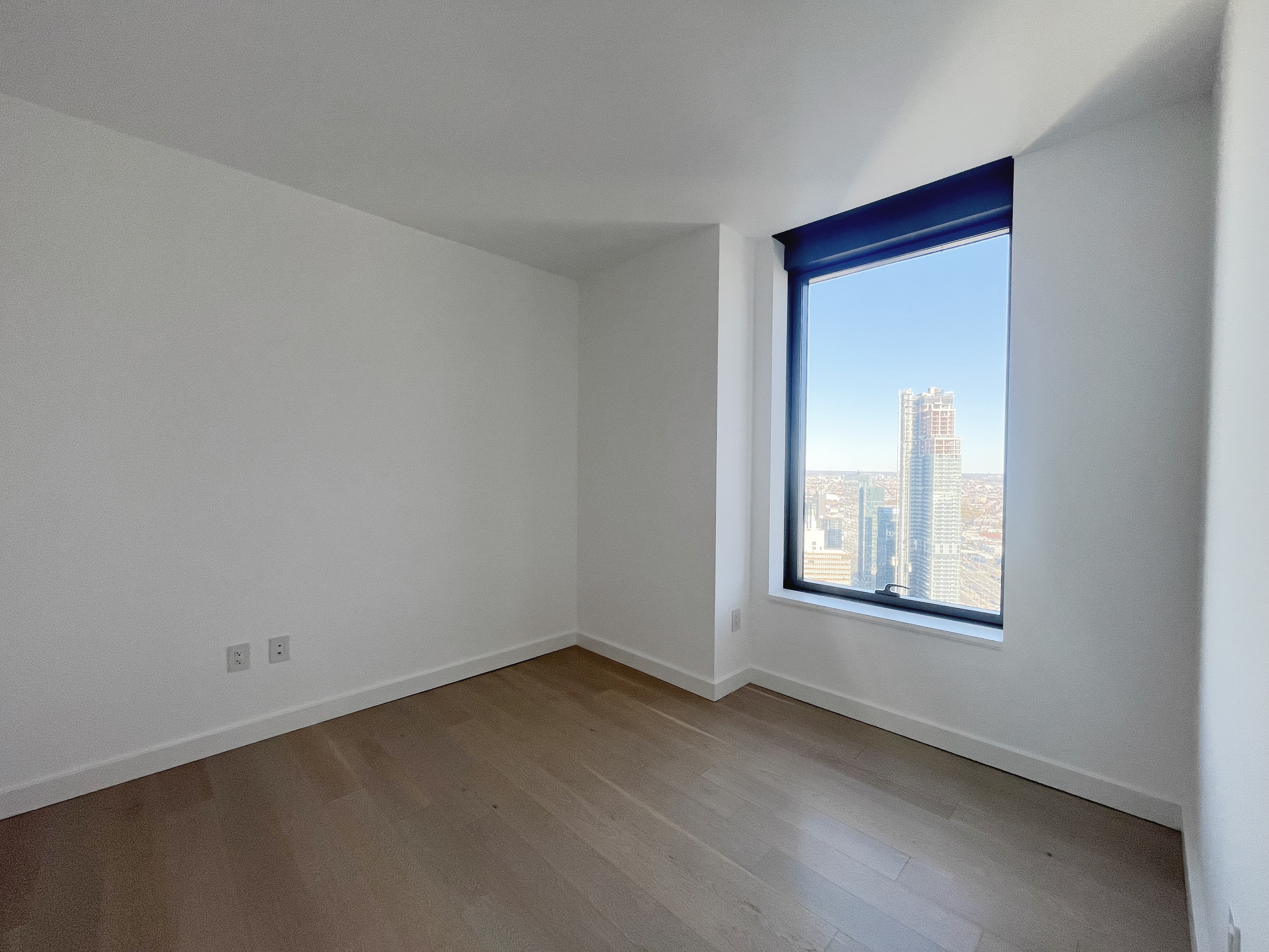 45-3 Court Square, Unit 5906 Queens, NY 11101 - Photo 4 of 12 an empty room with a window