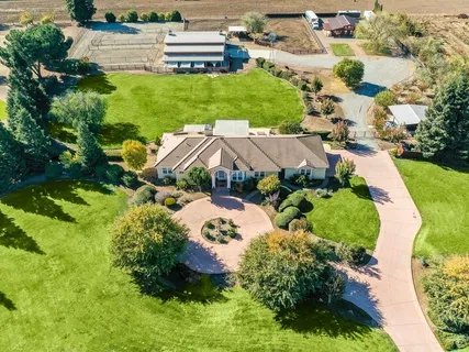 an aerial view of a house with a yard and lake view