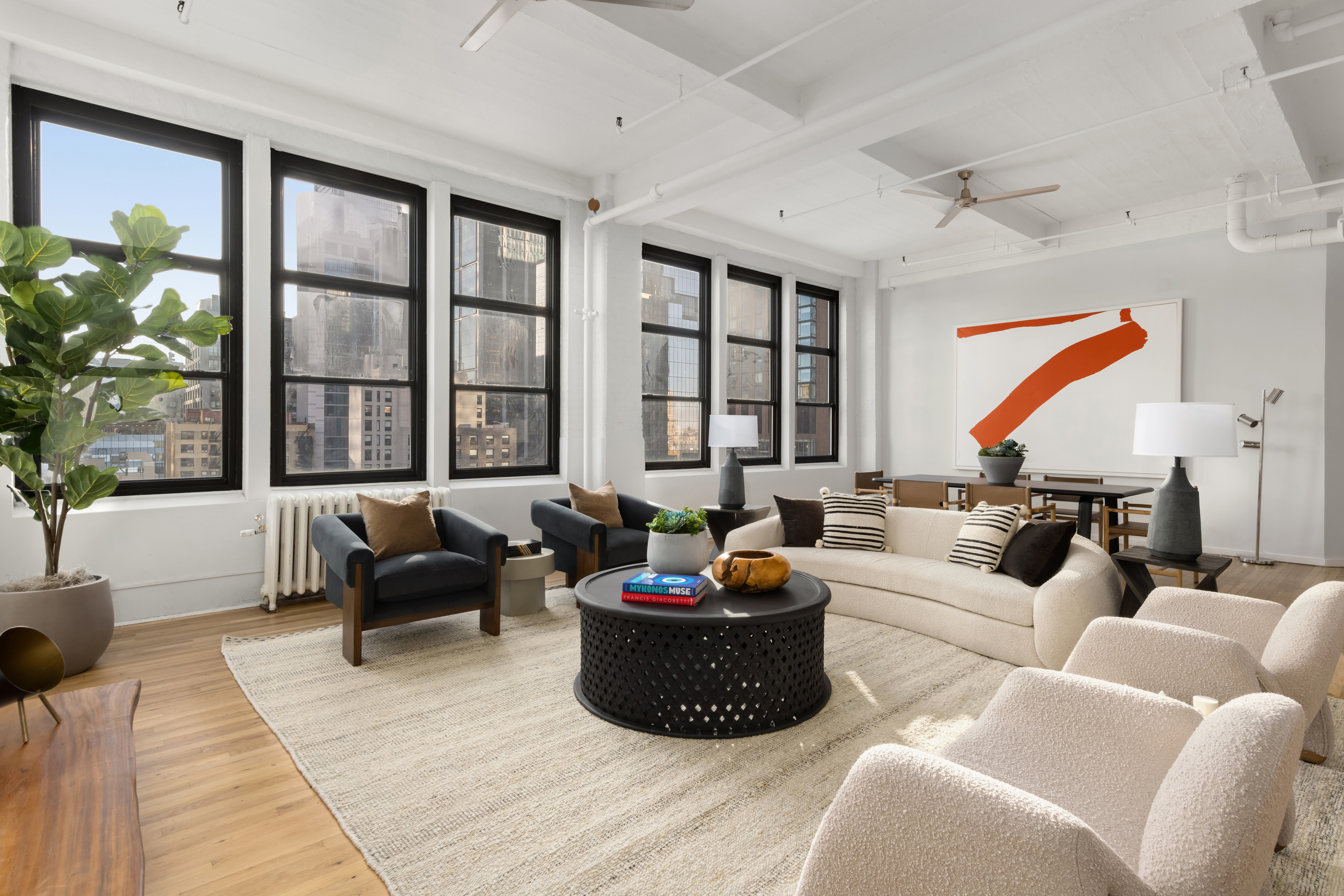 448 West 37th Street, Unit 12F Manhattan, NY 10018 - Photo 5 of 11 a living room with furniture and a large window