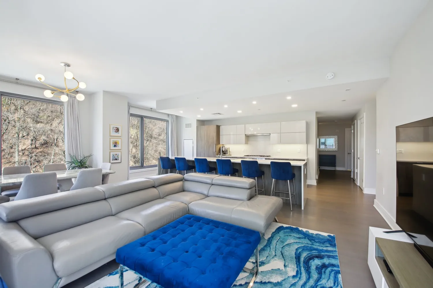 a living room with furniture a large window and a flat screen tv