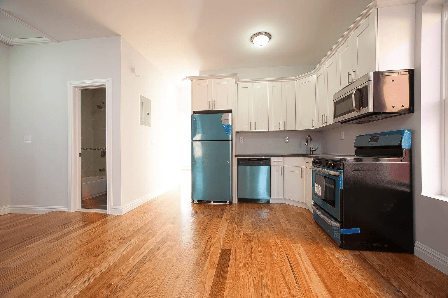581 Van Siclen Avenue Brooklyn, NY 11207 - Photo 6 of 16 a kitchen with stainless steel appliances granite countertop a refrigerator a stove top oven a sink and dishwasher with wooden floor
