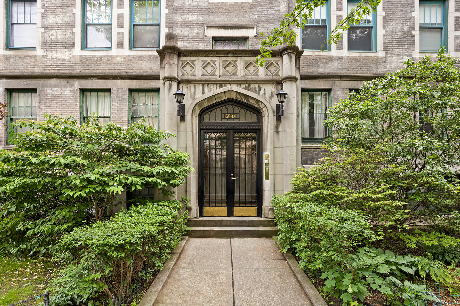 35-47 80th Street, Unit 2 Queens, NY 11372 - Photo 10 of 12 a view of a house with potted plants and a bench in front of main door