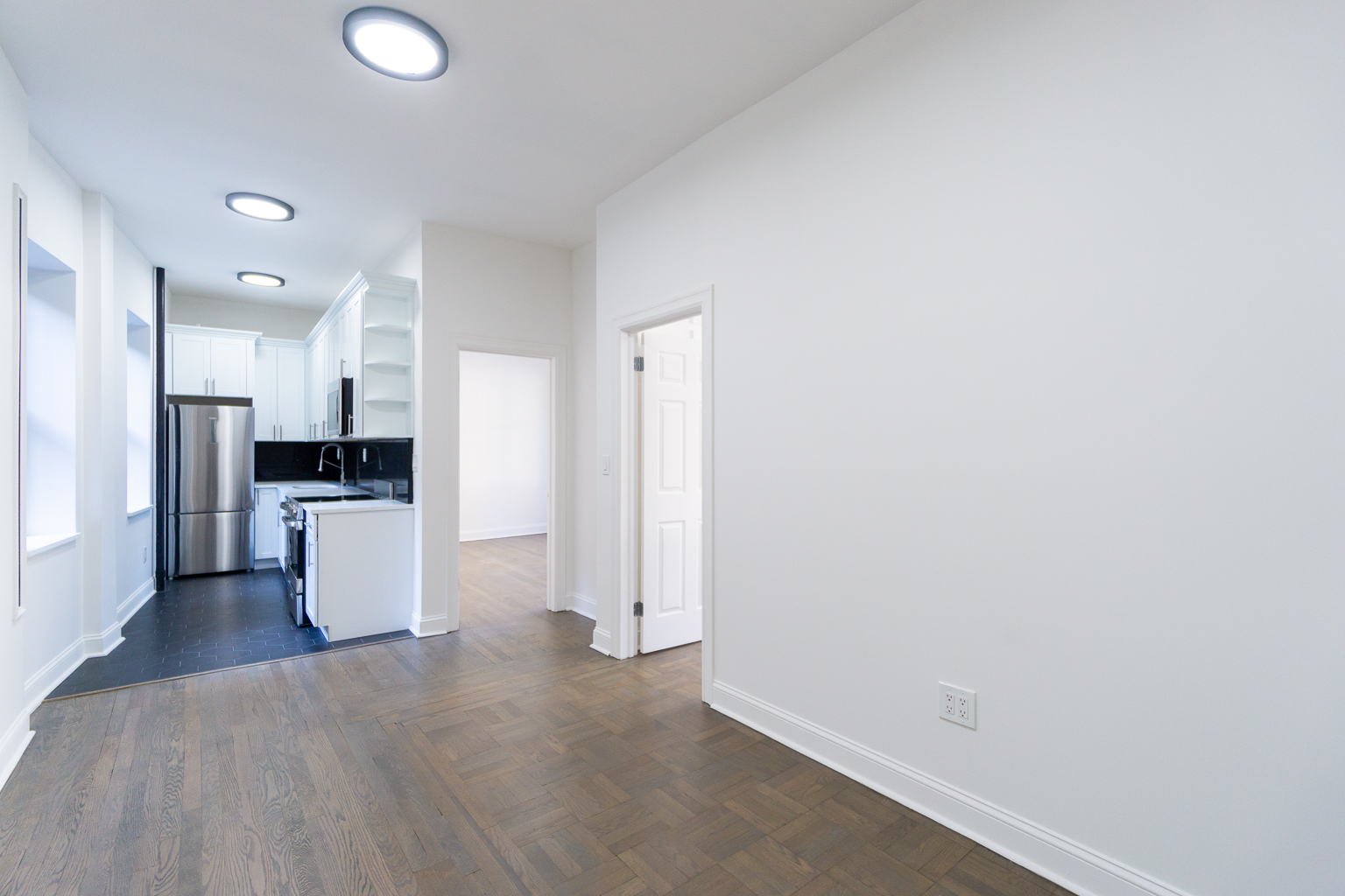 51 East 2nd Street, Unit 2 Manhattan, NY 10003 - Photo 5 of 18 an empty room with kitchen view and a refrigerator