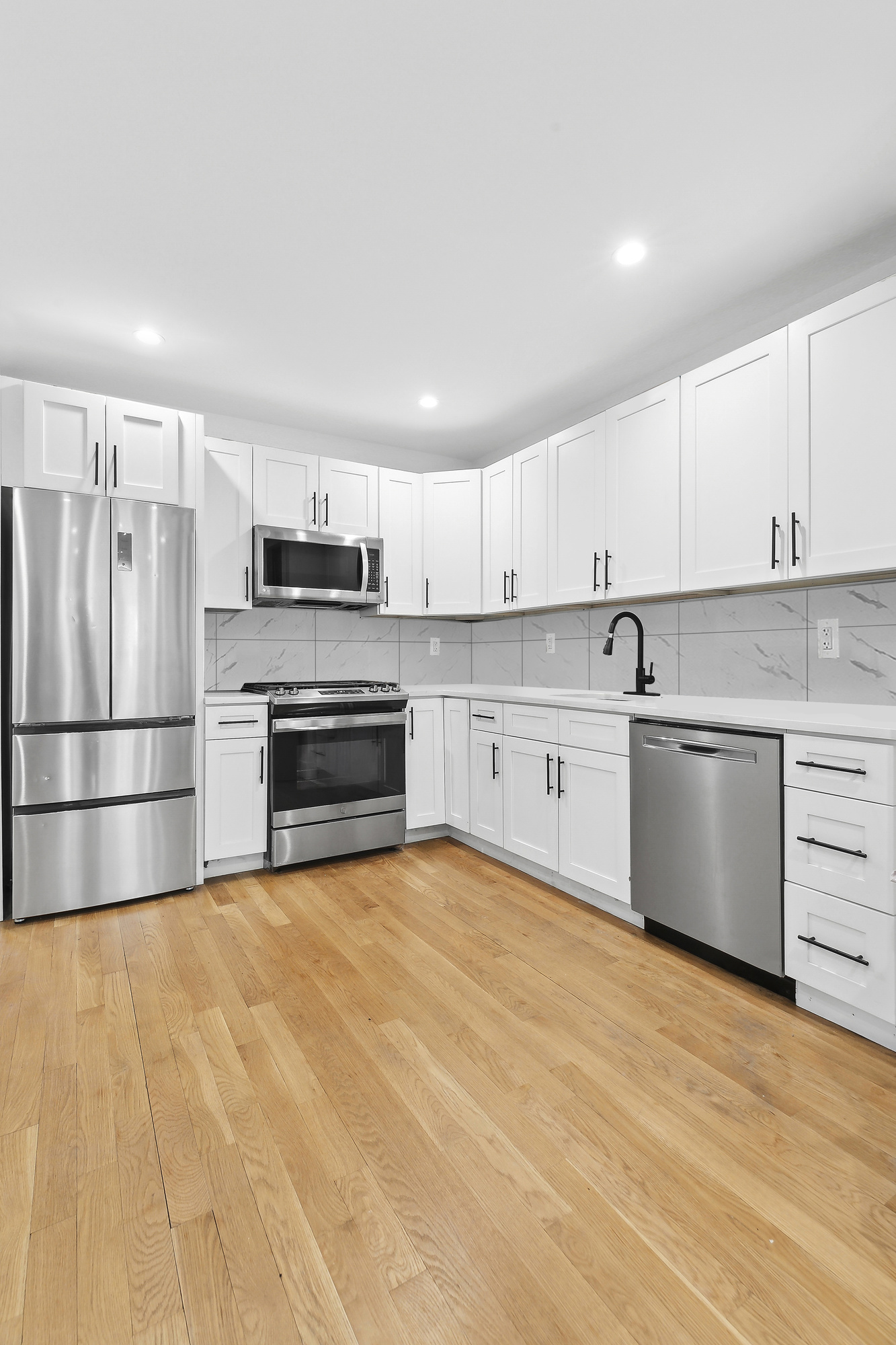 82 7th Avenue, Unit 3 Brooklyn, NY 11217 - Photo 4 of 12 a kitchen with stainless steel appliances granite countertop a refrigerator sink and cabinets