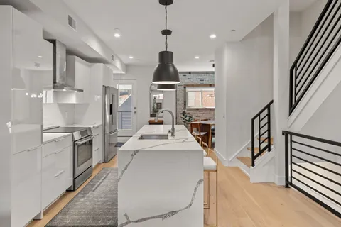 a large kitchen with stainless steel appliances kitchen island a stove a refrigerator a oven and a sink