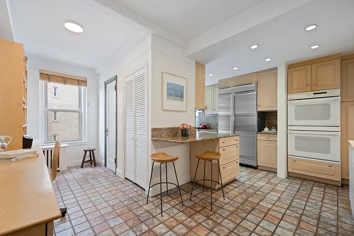 415 Central Park West, Unit 6A Manhattan, NY 10025 - Photo 12 of 25 a kitchen with white cabinets and appliances