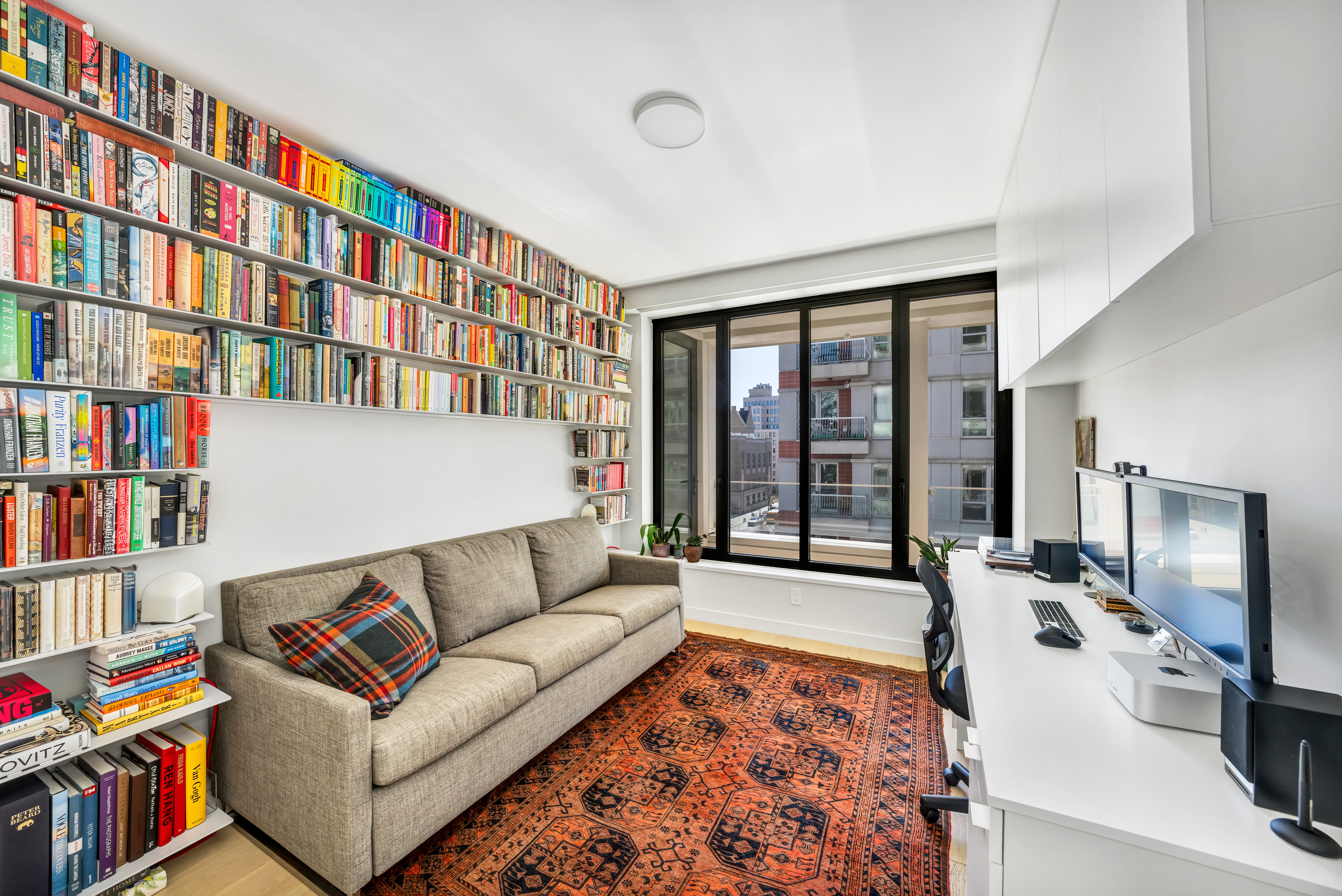 58 St Marks Place, Unit 608 Brooklyn, NY 11217 - Photo 10 of 22 a living room with furniture and a book shelf