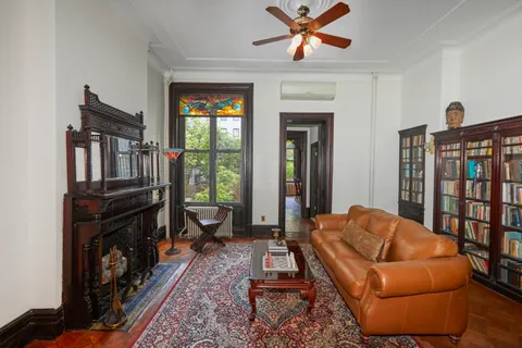 a living room with furniture ceiling fan and a window