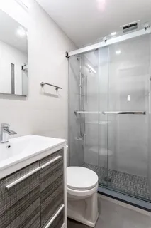 a bathroom with a sink a toilet and shower
