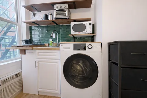 a utility room with stainless steel appliances and cabinets