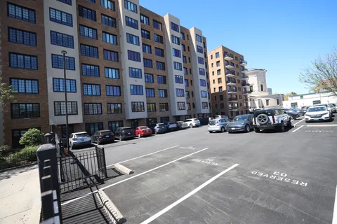 a city street lined with parked cars and buildings