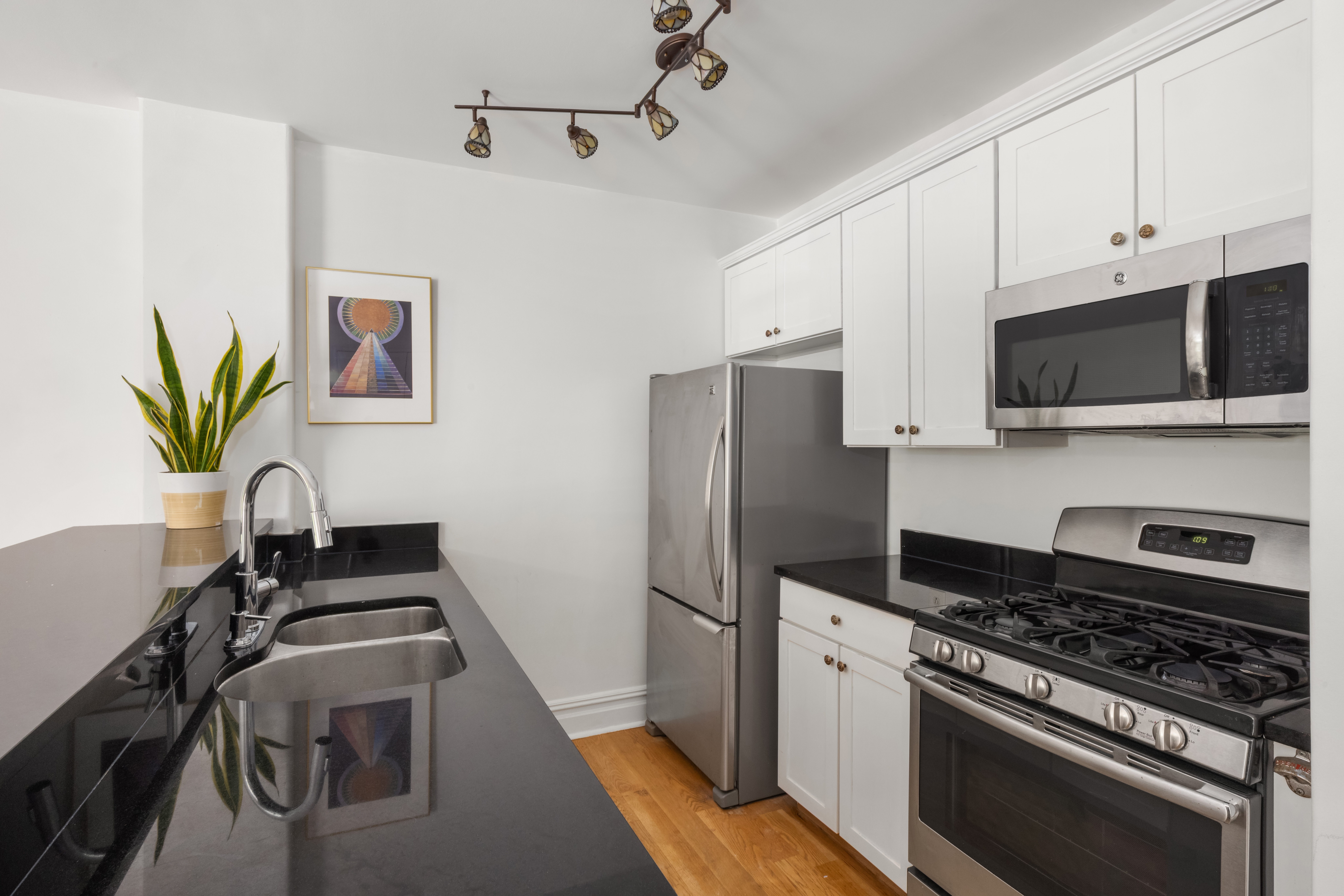 150 South 1st Street, Unit 2K Brooklyn, NY 11211 - Photo 3 of 12 a kitchen with stainless steel appliances a stove a refrigerator a sink a stove white cabinets and wooden floors