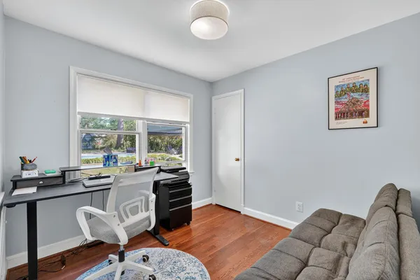 a view of a livingroom with workspace and a window
