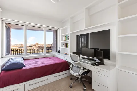 a bedroom with a bed and a desk