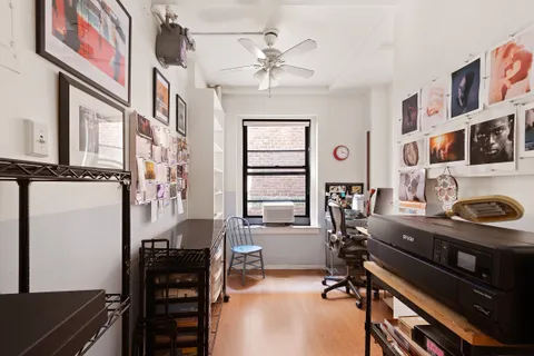 a view of a workspace with furniture and a window