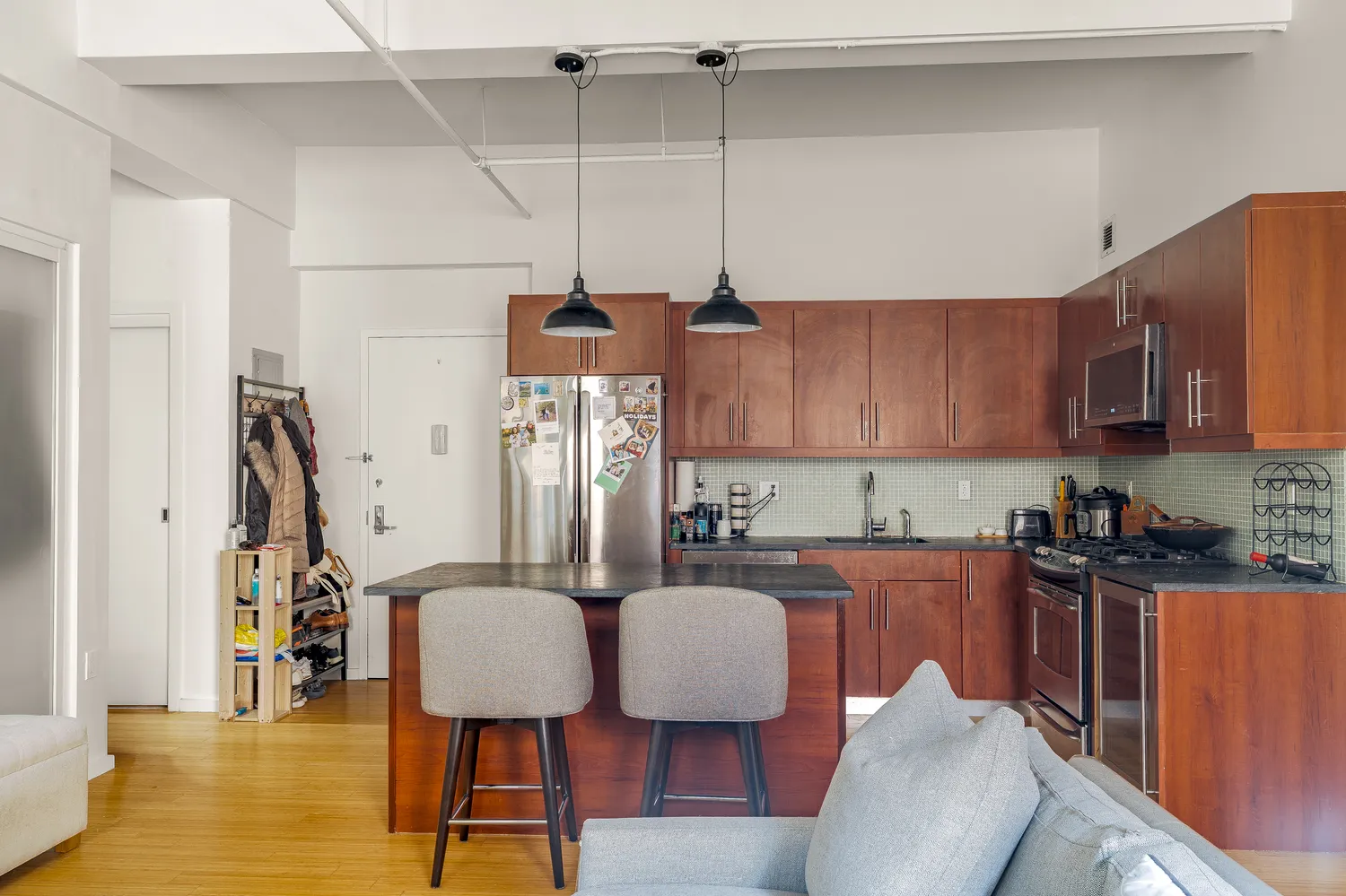 a kitchen with stainless steel appliances granite countertop a sink a microwave refrigerator and chairs