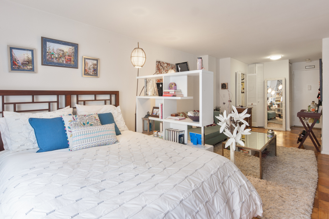 220 East 57th Street, Unit 12E Manhattan, NY 10022 - Photo 2 of 8 a bedroom with furniture and a large mirror