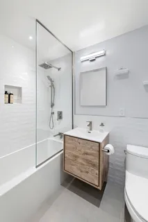 a bathroom with a sink a toilet and shower