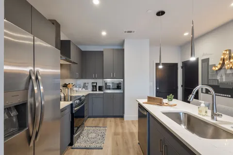 a kitchen with stainless steel appliances a sink stove and refrigerator
