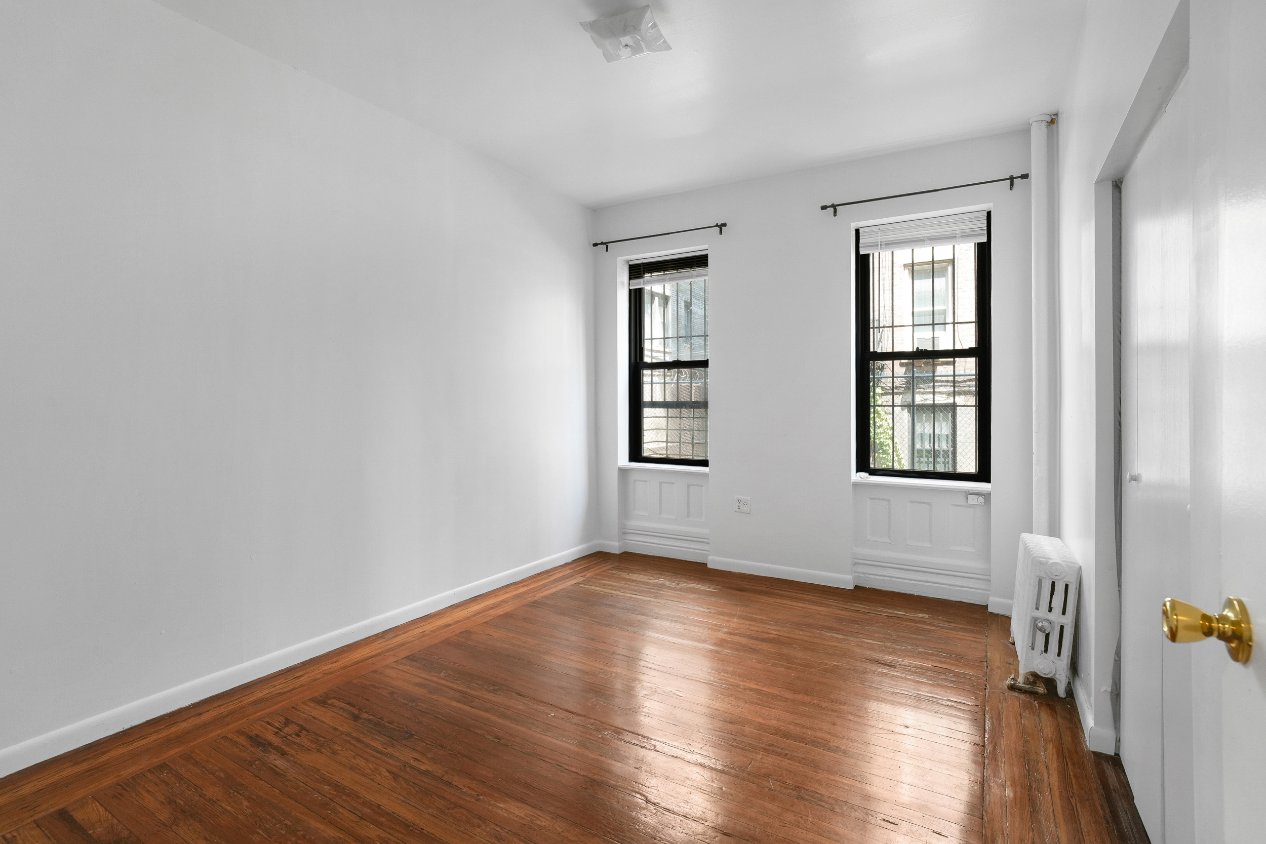 507 West 111th Street, Unit 3 Manhattan, NY 10025 - Photo 2 of 11 an empty room with wooden floor and windows