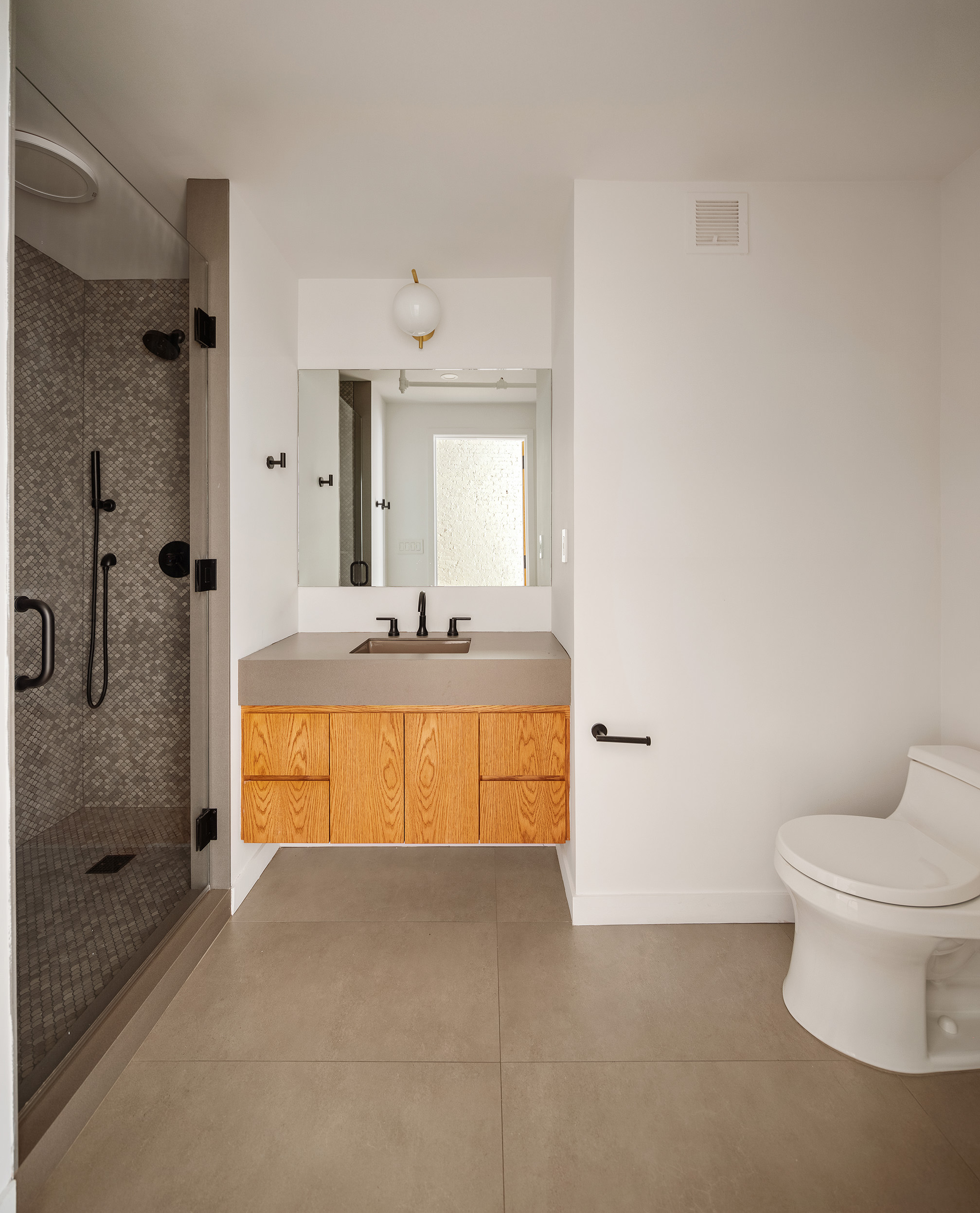 169 Mercer Street, Unit 2 Manhattan, NY 10012 - Photo 8 of 10 a bathroom with a granite countertop sink a toilet and shower