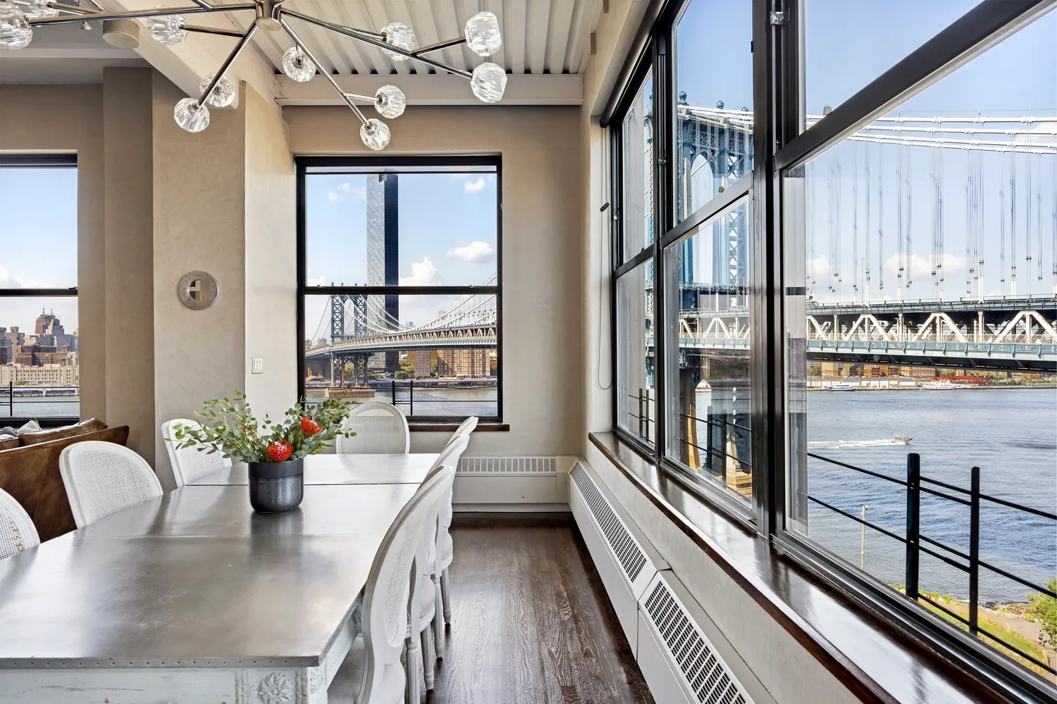 a dining room with furniture a potted plant and wooden floor