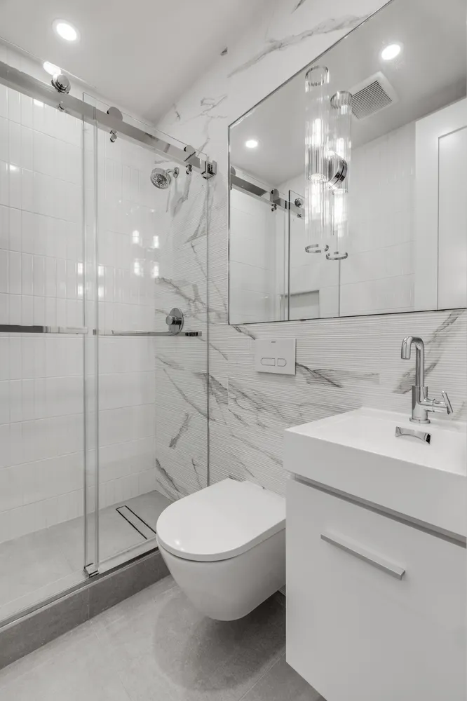 a bathroom with a sink a toilet and shower