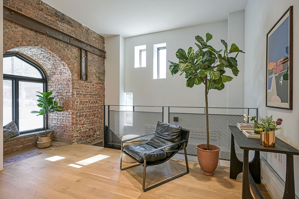 a living room with furniture a potted plant and a rug
