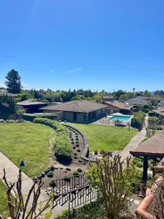 a view of a swimming pool with a garden and trees