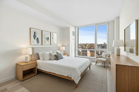 a bedroom with a bed and a large window