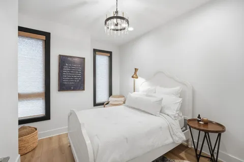 a bedroom with a bed and a chandelier