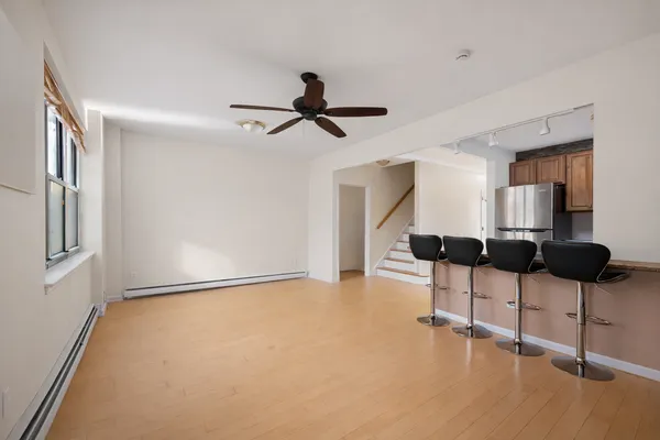 a view of an empty room with windows and ceiling fan