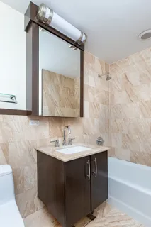 a bathroom with a sink vanity mirror and bathtub