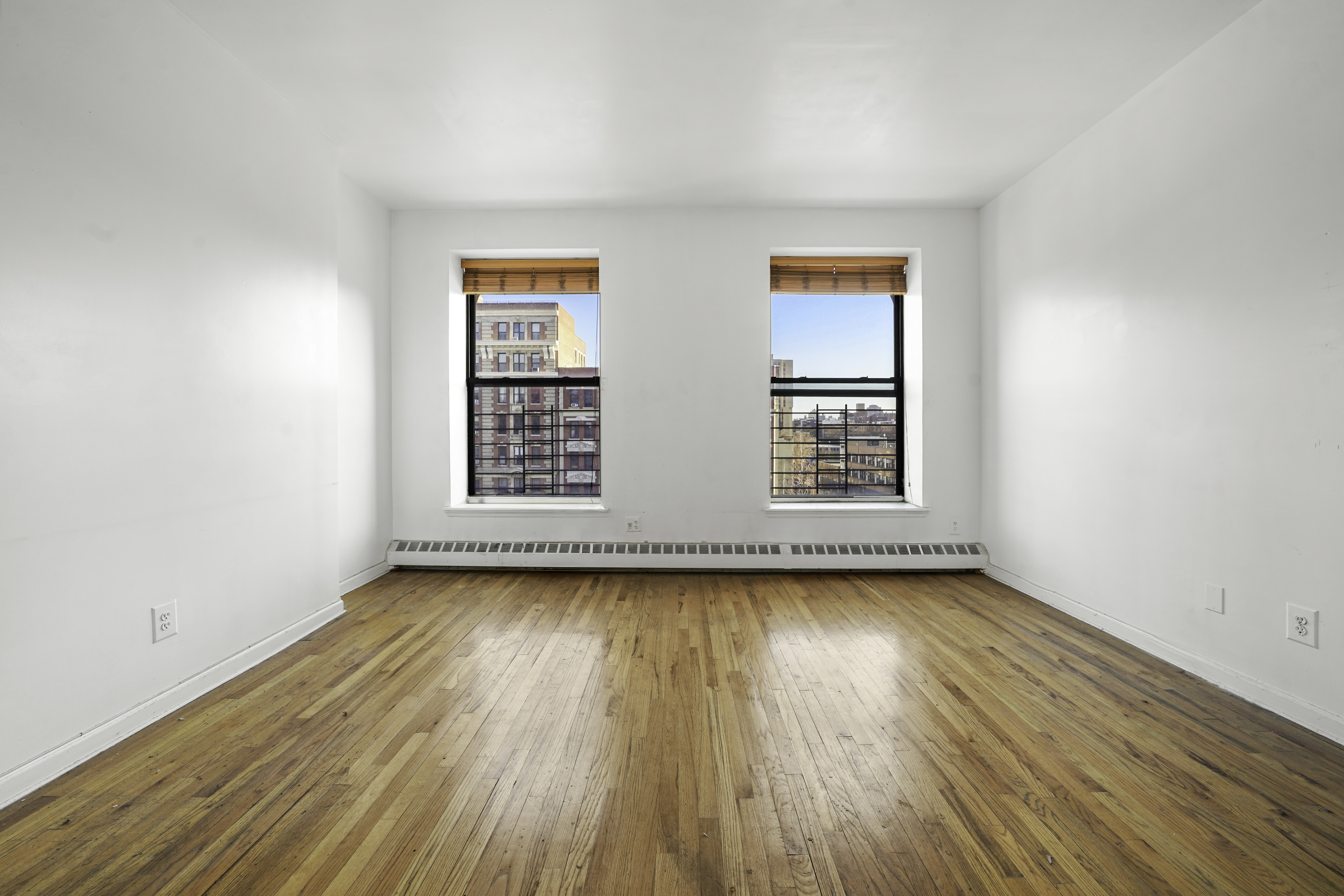 163 Lenox Avenue, Unit 5A Manhattan, NY 10026 - Photo 4 of 16 an empty room with wooden floor and windows