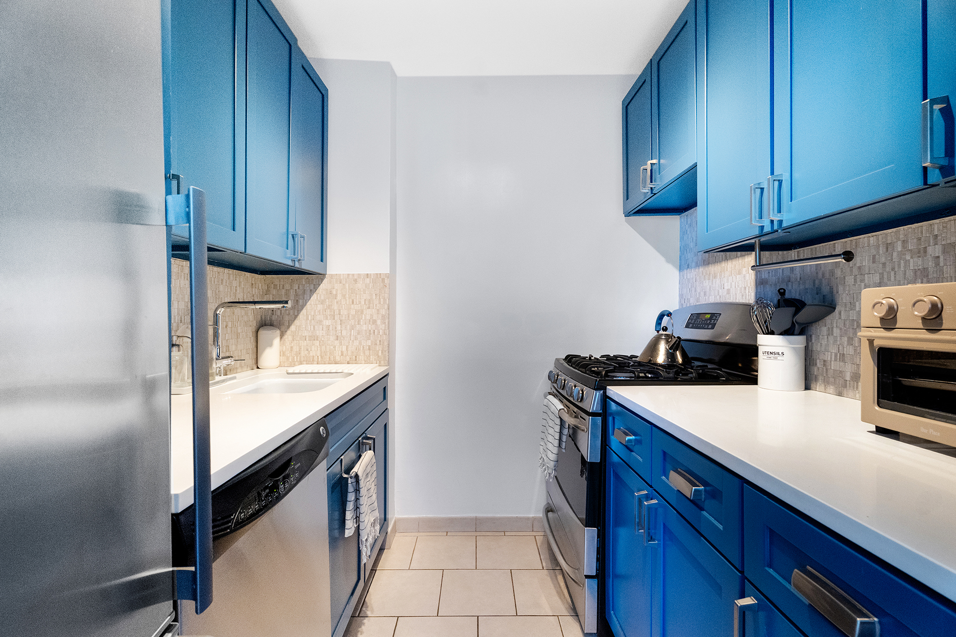 333 East 14th Street, Unit 10D Manhattan, NY 10003 - Photo 3 of 8 a kitchen with granite countertop cabinets and washing machine