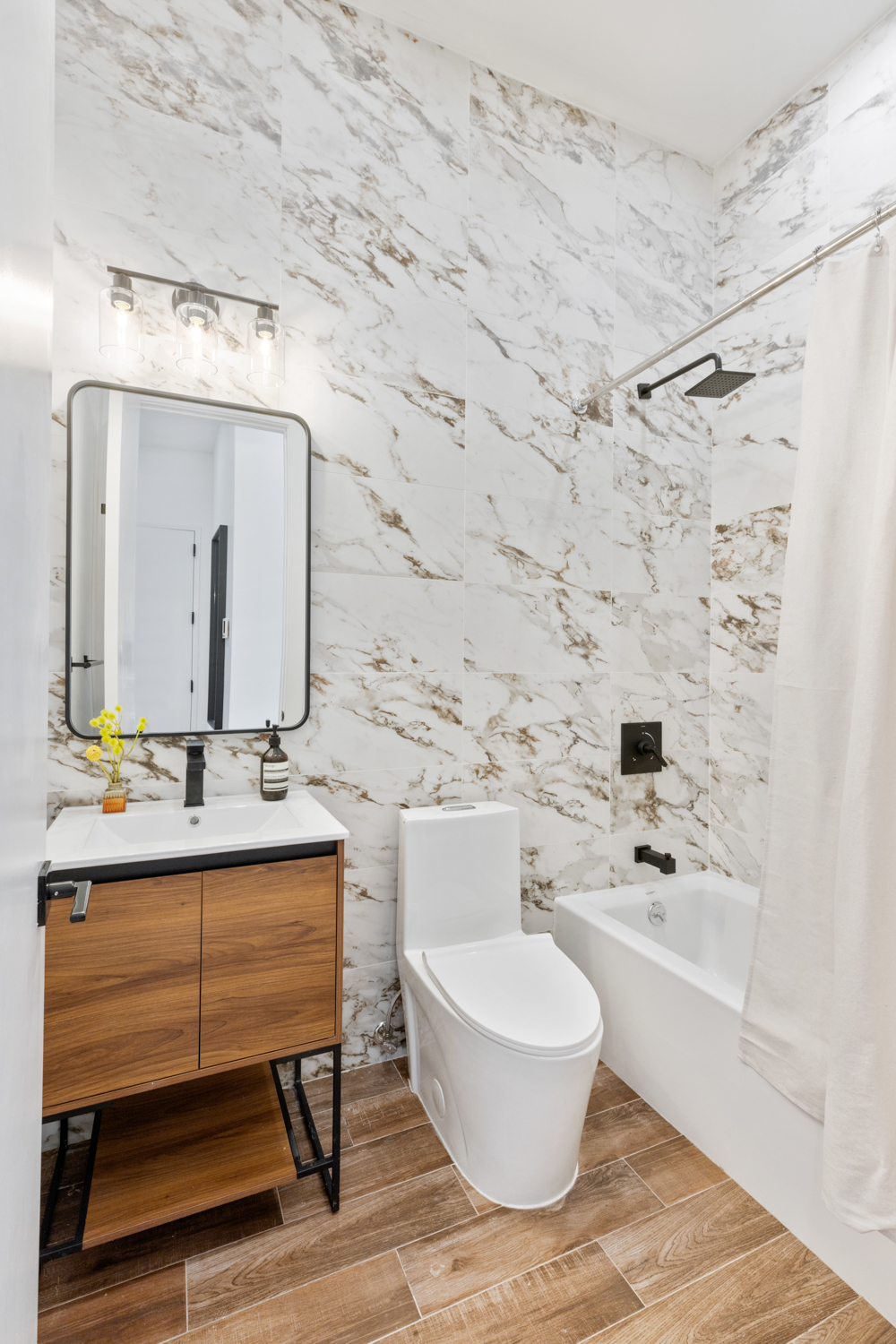 185 Withers Street, Unit 4 Brooklyn, NY 11211 - Photo 10 of 12 a bathroom with a bathtub a sink and a mirror