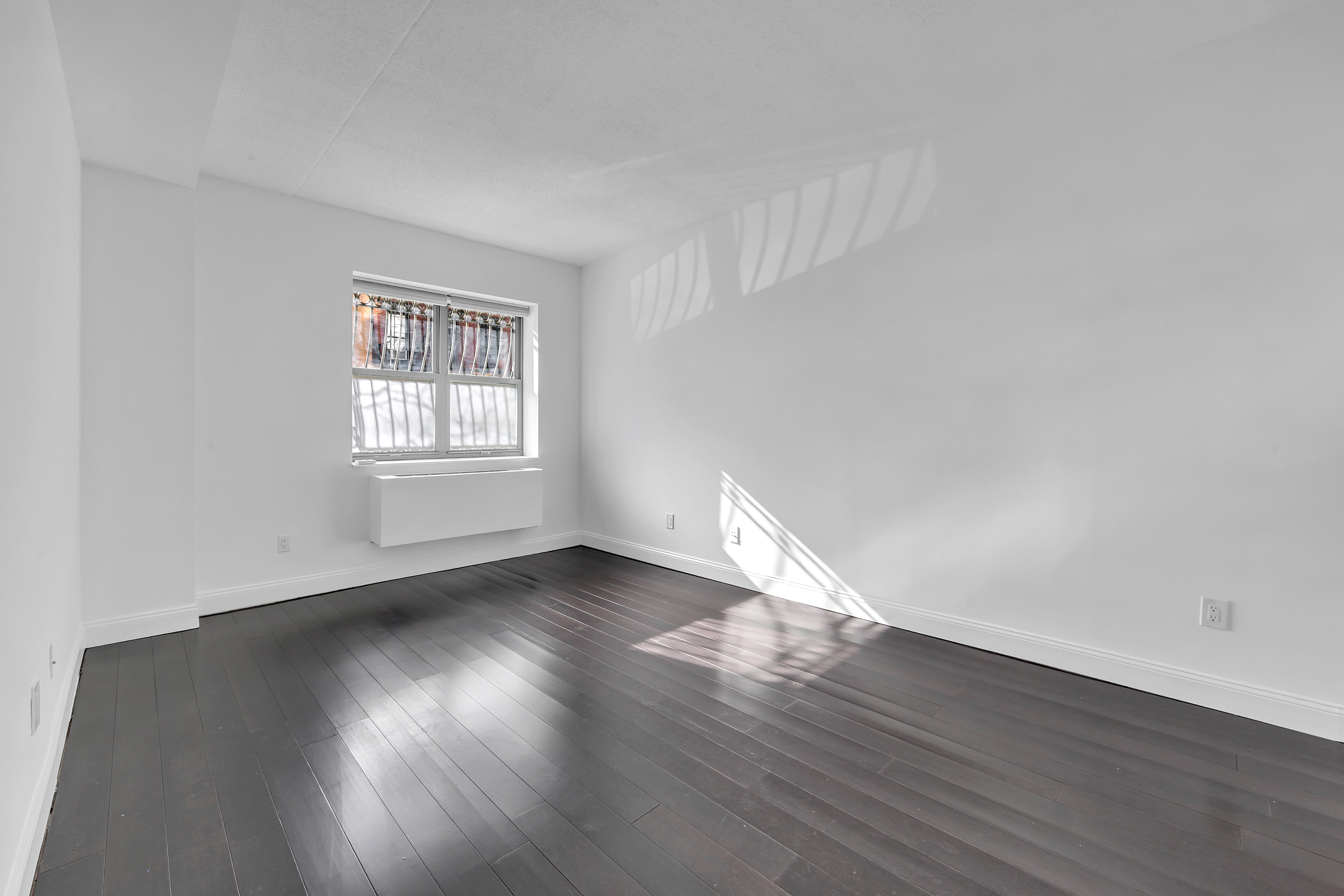 516 West 47th Street, Unit S1B Manhattan, NY 10036 - Photo 8 of 17 a view of an empty room with wooden floor and window